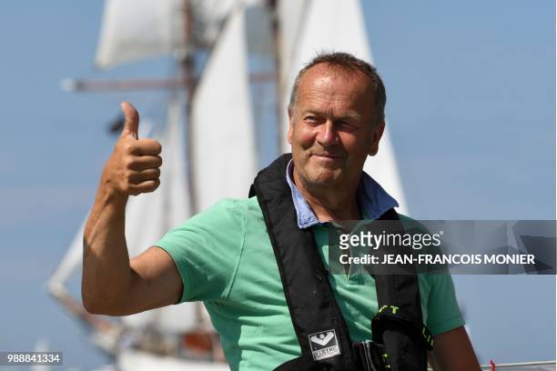 Estonian's Uku Randmaa waves on his boat "Rustler 36" as he sets sail from Les Sables d'Olonne Harbour on July 1 at the start of the solo...