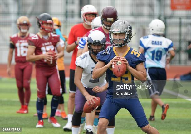 Football players take part in a training session with US football quarterback Russell Wilson at a football camp in Shanghai on July 1, 2018. / China...