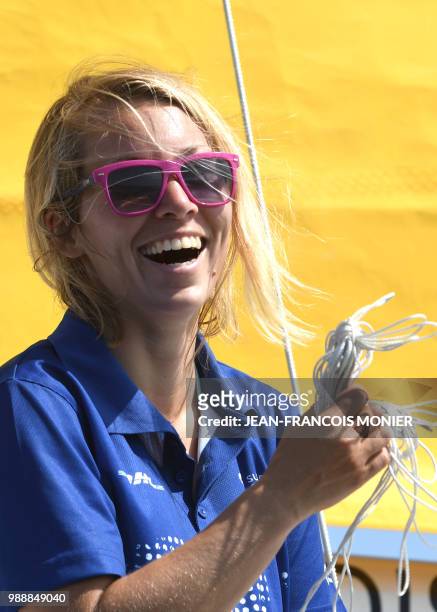 Britain's Susie Goodall smiles on her boat "DHL Starlight" as she sets sail from Les Sables d'Olonne Harbour on July 1 at the start of the solo...
