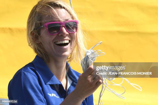 Britain's Susie Goodall smiles on her boat "DHL Starlight" as she sets sail from Les Sables d'Olonne Harbour on July 1 at the start of the solo...