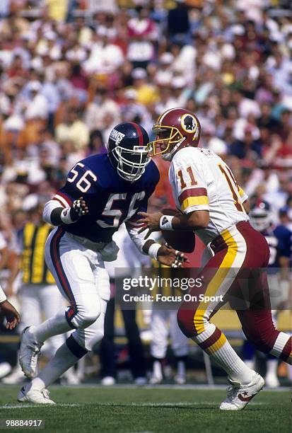 Linebacker Lawrence Taylor of the New York Giants rushes quarterback Mark Rypien of the Washington Redskins circa 1990 during an NFL football game at...
