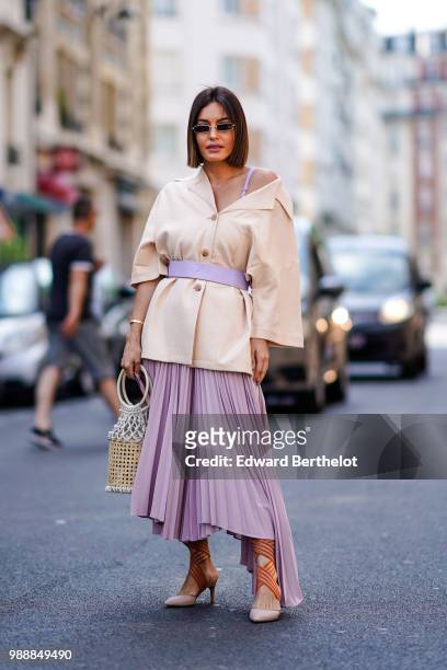 Guest wears a blazer jacket, a purple pale skirt, a basket bag, sunglasses , outside Acne Studios, during Paris Fashion Week - Womenswear Fall Winter...