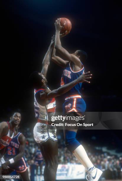 Darrell Walker of the New York Knicks shoots over Frank Johnson of the Washington Bullets during an NBA basketball game circa 1983 at the Capital...