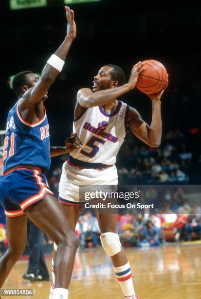 Darrell Walker of the Washington Bullets looks to pass the ball over the top of Gerald Wilkins of the New York Knicks during an NBA basketball game...