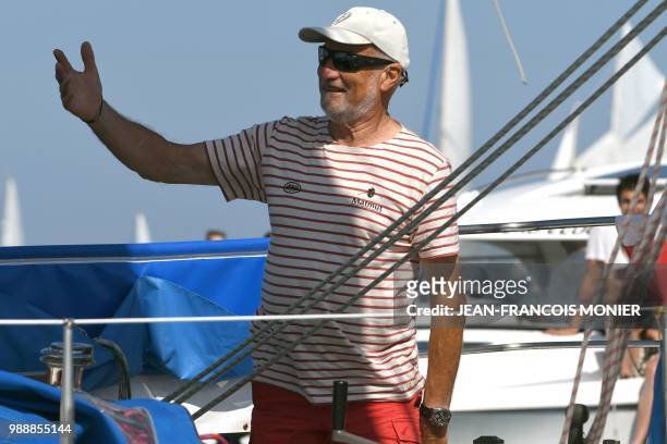 France's skipper Jean-Luc van den Heede gestures on his boat "Matmut" as he sets sail from Les Sables d'Olonne Harbour on July 1 at the start of the...