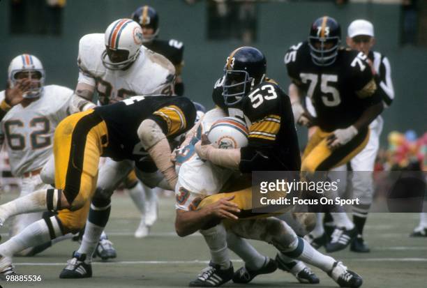 S: Running back Larry Csonka of the Miami Dolphins is brought down by linebacker Henry Davis of the Pittsburgh Steelers circa mid 1970's during an...