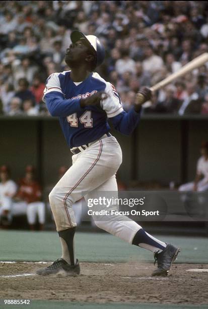 Outfielder Hank Aaron of the Atlanta Braves swings and watches the flight of his ball against the Cincinnati Reds circa 1974 during a Major League...