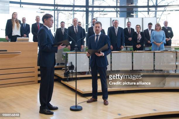 The new Prime Minister of Saxony, Michael Kretschmer , takes the oath of office next to President of the Parliament Matthias Roessler during the...