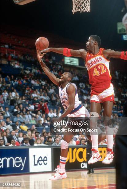 Darrell Walker of the Washington Bullets shoots over Kevin Willis of the Atlanta Hawks during an NBA basketball game circa 1989 at the Capital Centre...