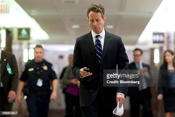 Timothy Geithner, U.S. Treasury secretary, checks his mobile phone while walking to a hearing of the Federal Inquiry Crisis Commission in Washington,...