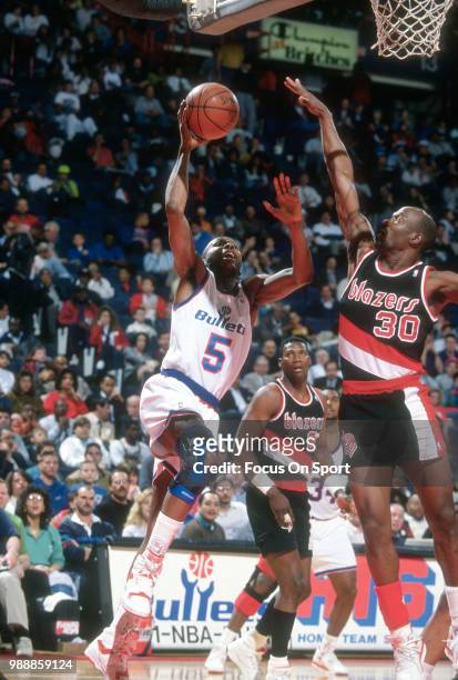 Darrell Walker of the Washington Bullets shoots over Terry Porter of the Portland Trail Blazers during an NBA basketball game circa 1991 at the...