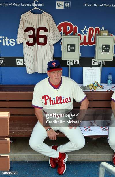 Manager Charlie Manuel of the Philadelphia Phillies sits in the dugout next to a jersey of Phillies Hall of Fame pitcher Robin Roberts prior to...