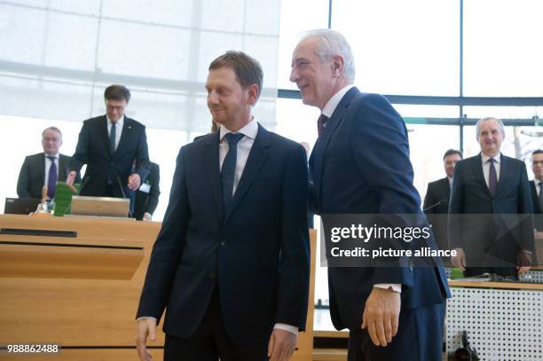 Saxony's former Prime Minister Stanislaw Tillich congratulates the new Prime Minister of Saxony, Michael Kretschmer during the meeting of the state...