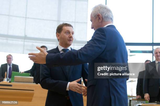 Saxony's former Prime Minister Stanislaw Tillich congratulates the new Prime Minister of Saxony, Michael Kretschmer during the meeting of the state...