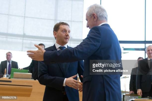 Saxony's former Prime Minister Stanislaw Tillich congratulates the new Prime Minister of Saxony, Michael Kretschmer during the meeting of the state...