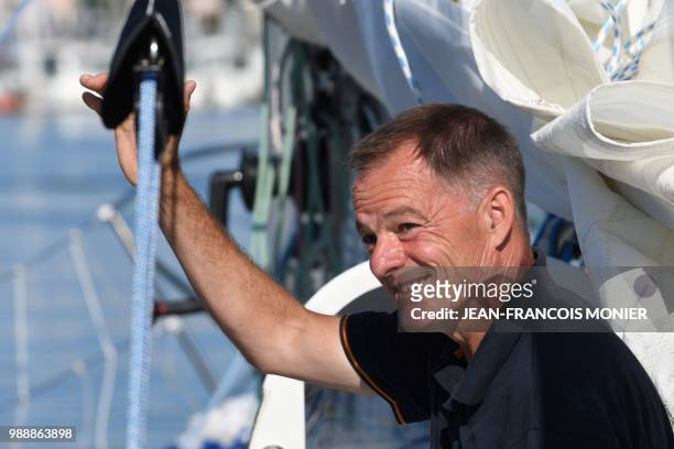 Finnish skipper Tapio Lehtinen gestures on his boat "Asteria" as he sets off in Les Sables d'Olonne Harbour on July 1 at the start of the solo...