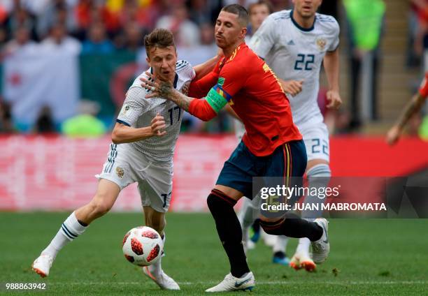 Russia's midfielder Aleksandr Golovin vies with Spain's defender Sergio Ramos during the Russia 2018 World Cup round of 16 football match between...