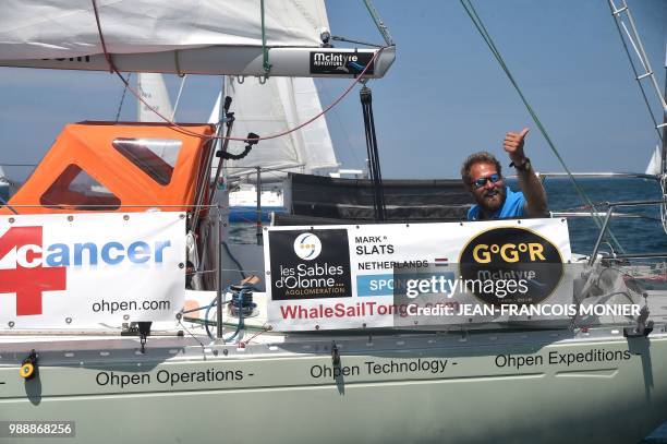 Dutch skipper Mark Slats waves from his boat "Ohpen Maverick" as he sets sail from Les Sables d'Olonne Harbour on July 1 at the start of the solo...