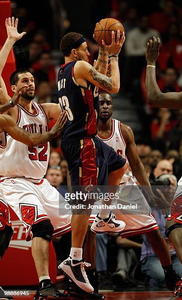Delonte West of the Cleveland Cavaliers leaps to pass over Brad Miller and Ronald Murray of the Chicago Bulls in Game Three of the Eastern Conference...