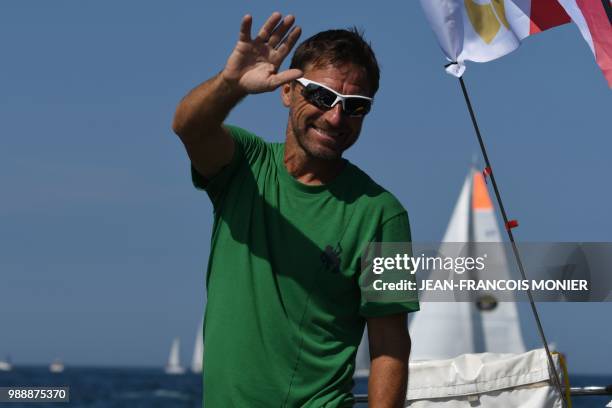 English born-Australian Kevin Farebrother waves on his boat "Sagarmatha" as he sets sail from Les Sables d'Olonne Harbour on July 1 at the start of...