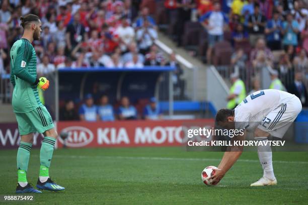 Russia's forward Artem Dzyuba drops the ball on the penalty spot before scoring their first goal to Spain's goalkeeper David De Gea during the Russia...