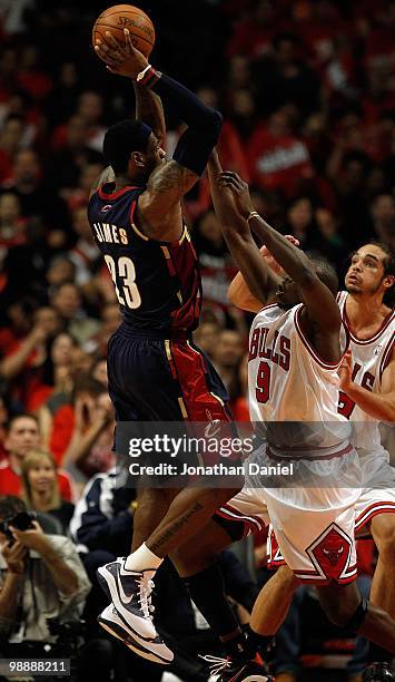 LeBron James of the Cleveland Cavaliers shoots over Luol Deng and Joakim Noah of the Chicago Bulls in Game Three of the Eastern Conference...