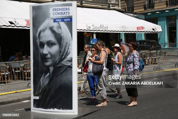 People stand by a portrait of former French politician and Holocaust survivor Simone Veil on the rue Soufflot following the burial ceremony at the...