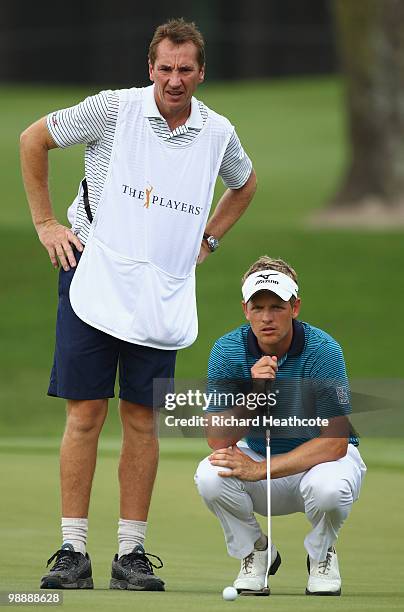 Luke Donald of England lines up a putt on the 16th green with the help of his caddie during the first round of THE PLAYERS Championship held at THE...