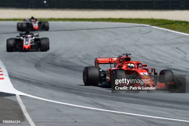 Sebastian Vettel of Germany driving the Scuderia Ferrari SF71H leads Romain Grosjean of France driving the Haas F1 Team VF-18 Ferrari on track during...