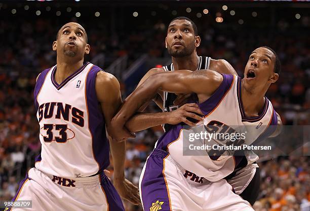 Grant Hill and Channing Frye of the Phoenix Suns guard against Tim Duncan of the San Antonio Spurs during Game One of the Western Conference...