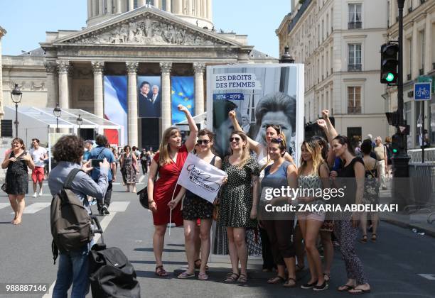 Members of "Osez le Feminism" pose by a portrait of former French politician and Holocaust survivor Simone Veil on the rue Soufflot in Paris...