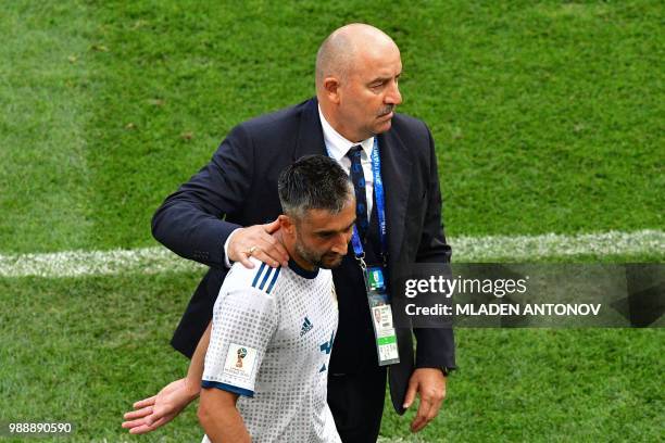 Russia's midfielder Alexander Samedov is congratulated by Russia's coach Stanislav Cherchesov as he is replaced during the Russia 2018 World Cup...