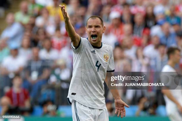 Russia's defender Sergey Ignashevich gestures during the Russia 2018 World Cup round of 16 football match between Spain and Russia at the Luzhniki...