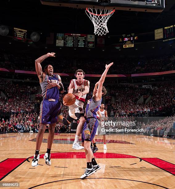 Rudy Fernandez of the Portland Trail Blazers goes up for a shot between Channing Frye and Goran Dragic of the Phoenix Suns in Game Six of the Western...