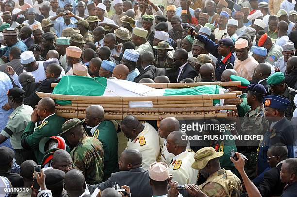 Senior military officers carry the body of late Nigerian President Umaru Musa Yar'Adua amidst thousands of mourners, from the Katsina Stadium to the...