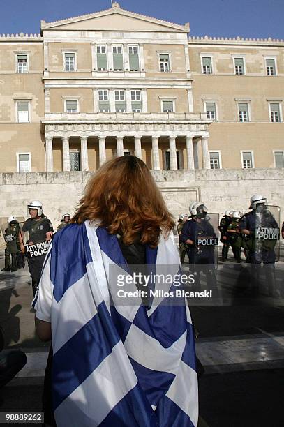 Protester draped in a Greek flag stands in front of Greece's parliament buildings during an anti-government rally on May 6, 2010 in Athens, Greece....