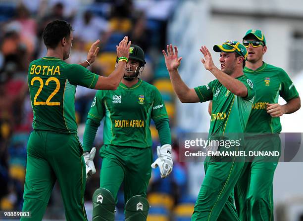 South African bowler Johan Botha celebrates with teammate AB de Villiers after the dismissal of New Zealand batsman Jesse Ryder during the ICC World...