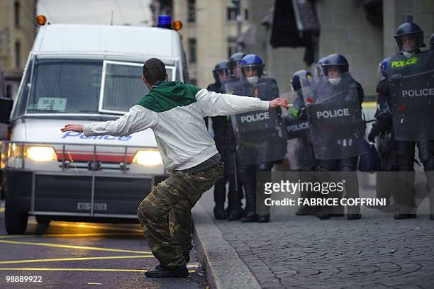 Riot policemen face a demonstrator on May 6, 2010 in Lausanne, during a protest against the death of a prisoner after media reported that guards...