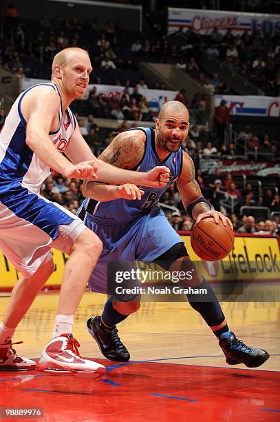 Carlos Boozer of the Utah Jazz dribble drives against Chris Kaman of the Los Angeles Clippers during the game on March 1, 2010 at Staples Center in...