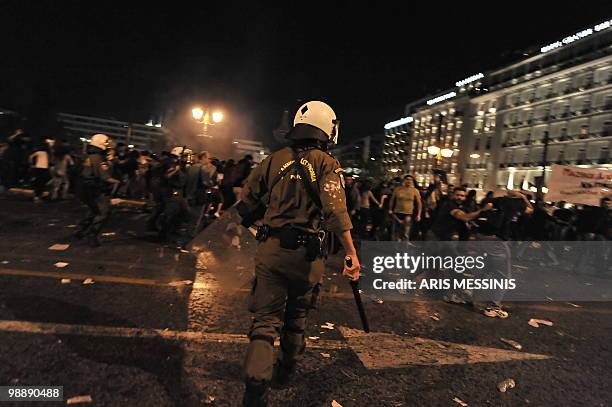 Demonstrators run away from riot police during a protest in front of the Greek Parliament on May 6, 2010. More than 10,000 people demonstrated...