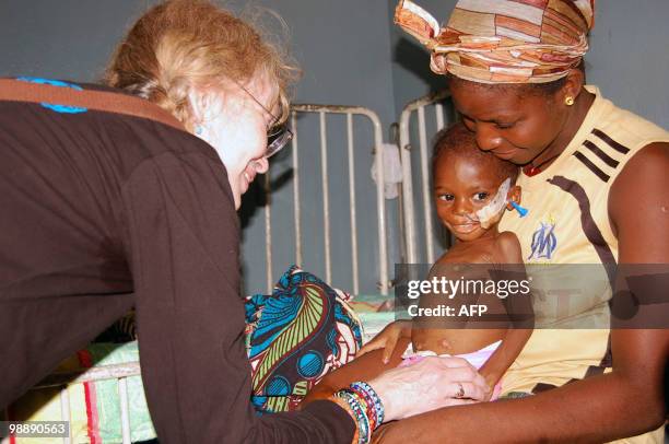 Actress Mia Farrow humanitarian and volunteer UNICEF Ambassador looks at a sick child on May 6, 2010 in a health center in Conakry. Farrow is on a 5...