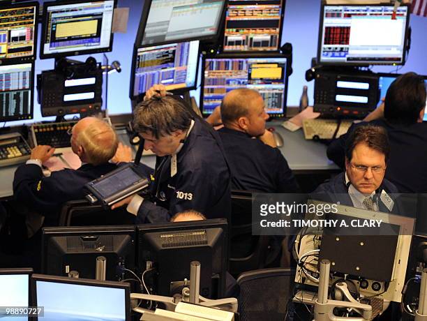 Traders on the floor of the New York Stock Exchange look at stocks during the final minutes of trading May 6, 2010 as the Dow lost almost 1,000...