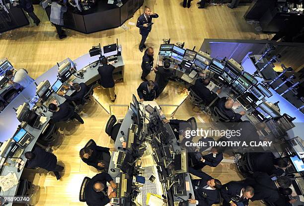 Traders on the floor of the New York Stock Exchange look at stocks during the final minutes of trading May 6, 2010 as the Dow lost almost 1,000...