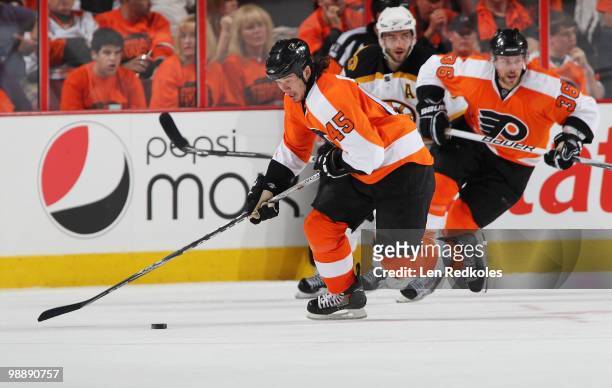 Arron Asham and Darroll Powe of the Philadelphia Flyers skate the puck out of their zone against Patrice Bergeron of the Boston Bruins in Game Three...