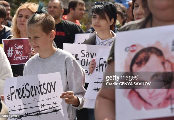 People hold placards with an appeal to free Ukrainian film director Oleg Sentsov during a rally in Kiev on July 1 to demand the release Oleg Sentsov...