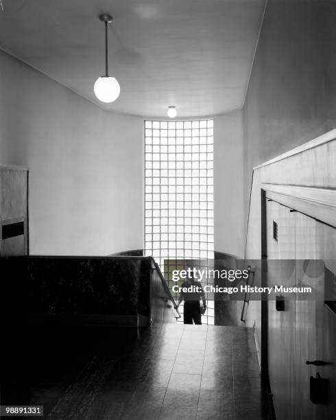 Interior view showing a boy walking up the stairs with the glass blocks behind him, at the Grimes School building, June 1940. The school is located...