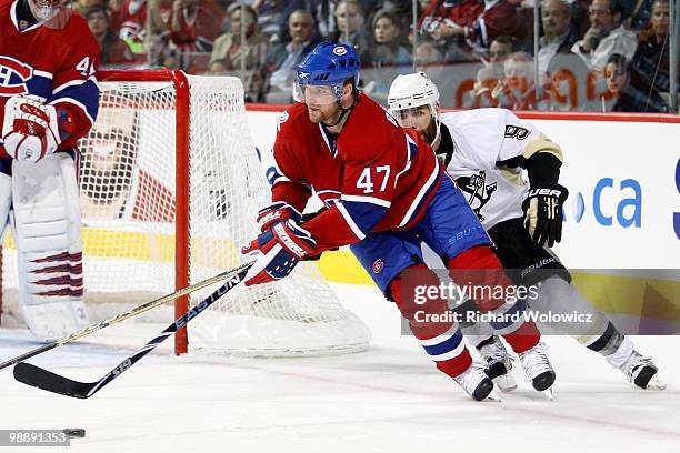 Marc-Andre Bergeron of the Montreal Canadiens skates with the puck while being chased by Pascal Dupuis of the Pittsburgh Penguins in Game Three of...