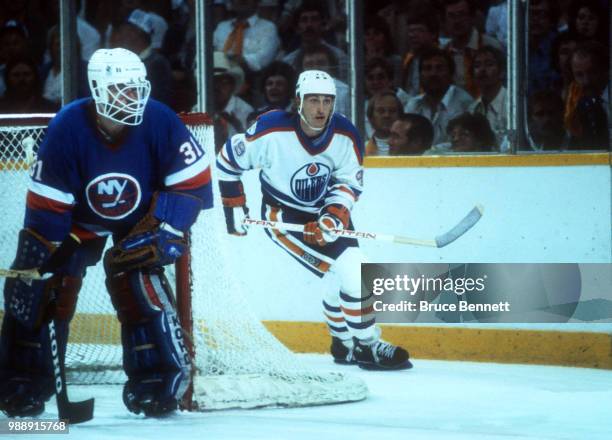 Wayne Gretzky of the Edmonton Oilers skates around the net as goalie Billy Smith of the New York Islanders follows the play during the 1983 Stanley...