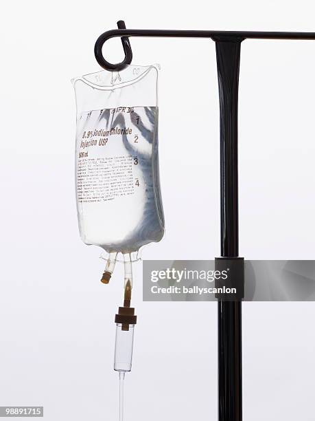 intravenous saline drip on iv pole. - infuus stockfoto's en -beelden