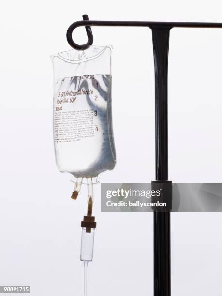 intravenous saline drip on iv pole. - iv drip stock pictures, royalty-free photos & images